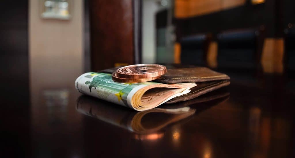 Uma carteira com dinheiro em cima de uma mesa.
