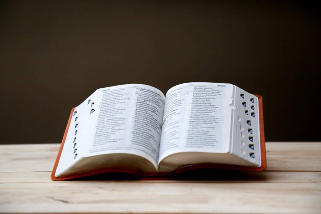 Uma Bíblia aberta sobre uma mesa de madeira.